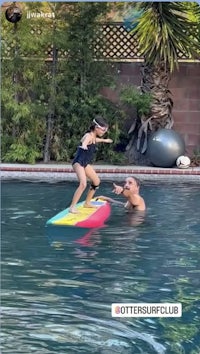 a man and a child on a surfboard in a pool