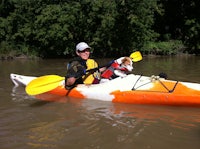 a man in a kayak with a dog